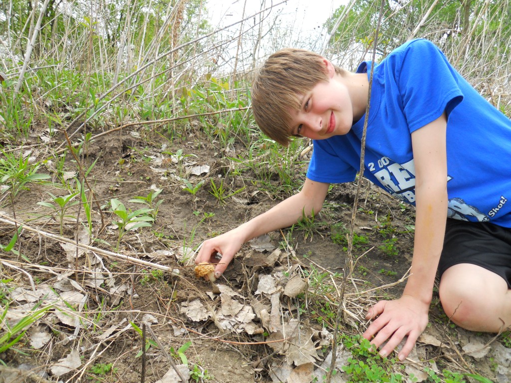 Youngster picking a morel mushroom along the Elkhorn River. Photo by Greg Wagner.