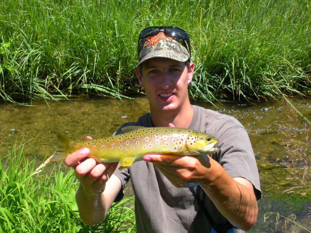 Daniel Bauer of Lincoln, NE poses with a brown trout he caught in a northwestern Nebraska Pine Ridge stream. Photo courtesy of Daryl Bauer/Nebraska Game and Parks Commission.