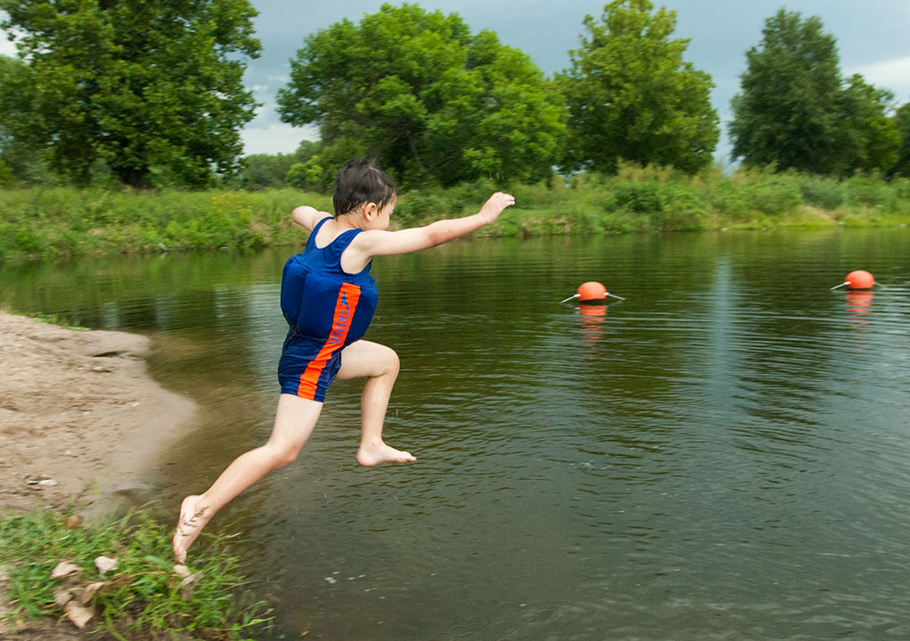Boy jumping into Two Rivers State Recreation Area.