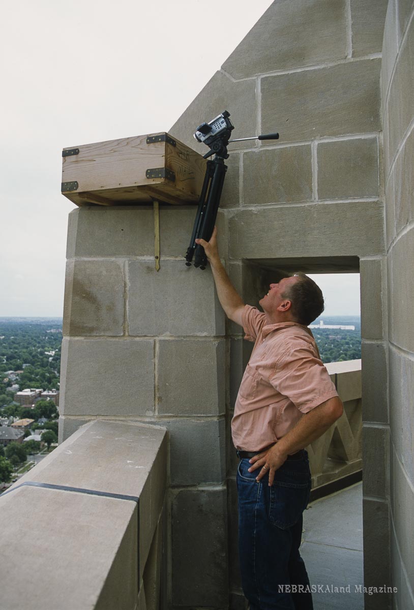 CAPITOL PEREGRINES: Game and Parks employees help re-establish a pair of breeding falcons (Falco peregrinus) in downtown Lincoln. John Dinan, Wildlife Div. Biologist, checks the nestbox fir birds before reaching up and removing un-fertilized eggs. Carroll, June 2003. Copyright NEBRASKAland Magazine, Nebraska Game and Parks Commission.