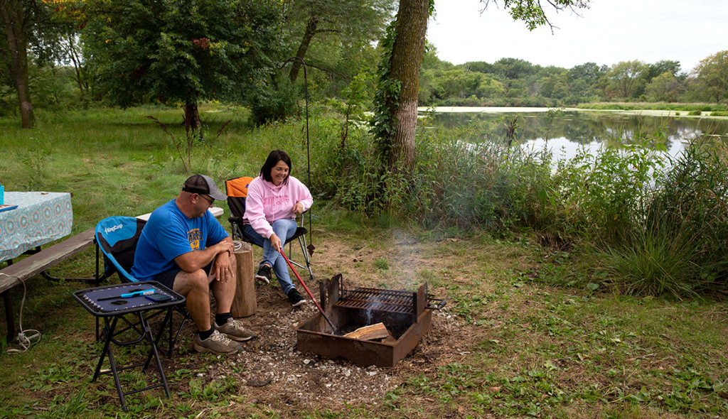 A couple sitting by a campfire.