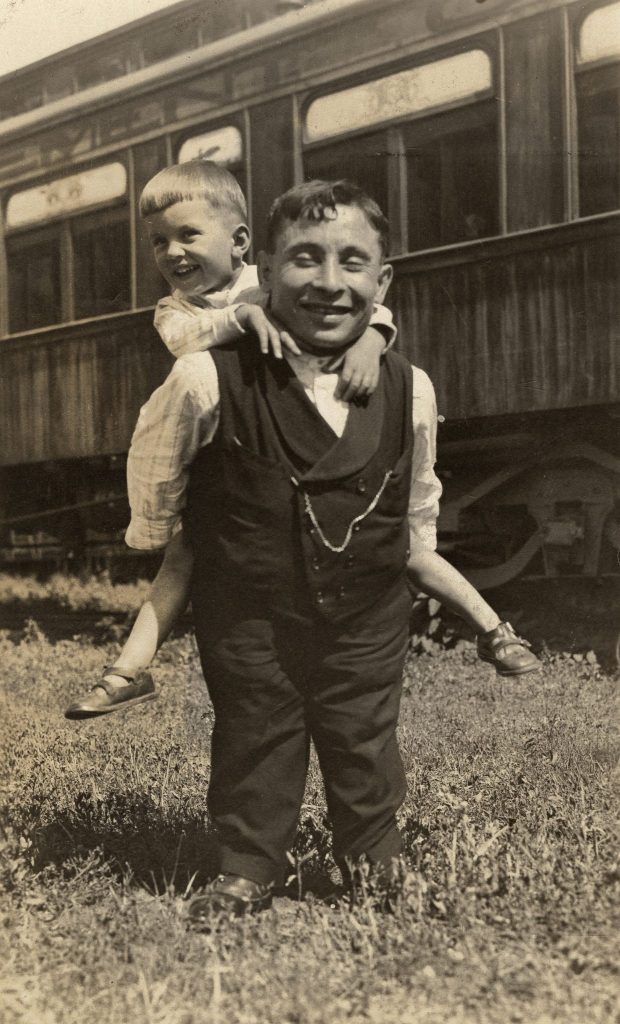 A little person and his son who were part of a traveling carnival pose for a portrait in the early 1900s.