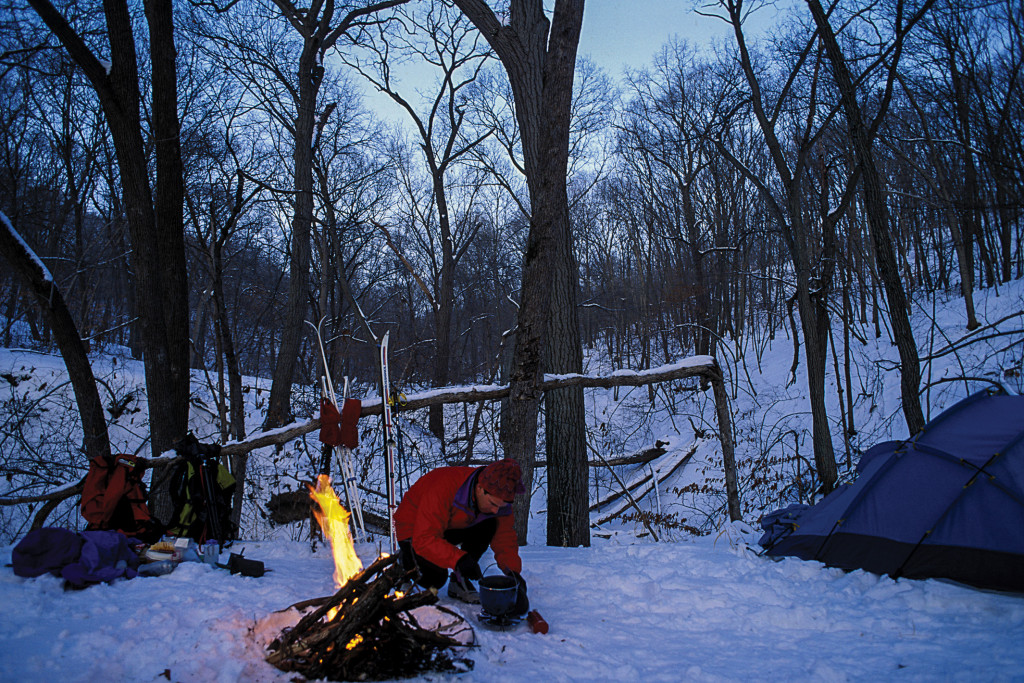 A man winter camping in the snow.