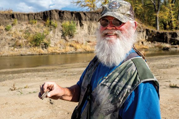 A man finds an Ice Age bison booth along the Big Nemaha River.