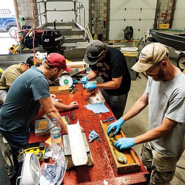 A group of men conduct fish research in a garage