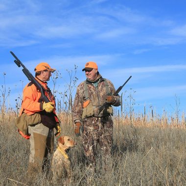 Two men and a dog upland hunting