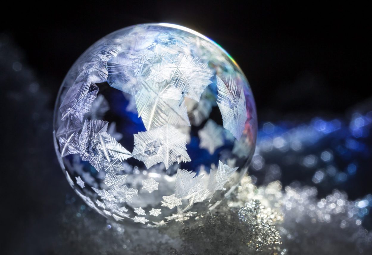 Macro photo of a soap bubble in the snow.