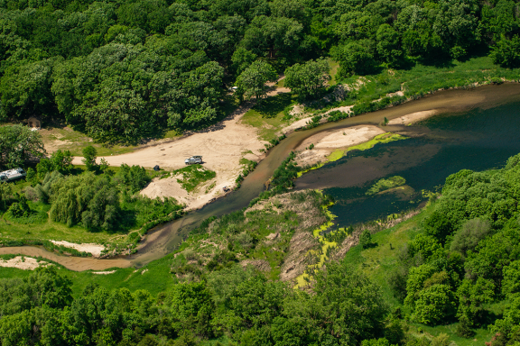 Aerial photo of a tree-lined creek during summer on a wildlife management area in Nebraska.