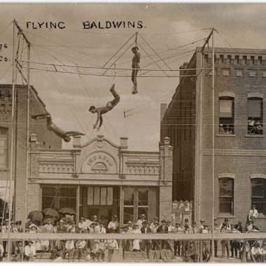 People doing acrobatics at a carnival in a Nebraska town in the early 1900s.