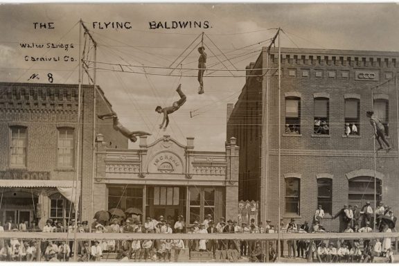 People doing acrobatics at a carnival in a Nebraska town in the early 1900s.