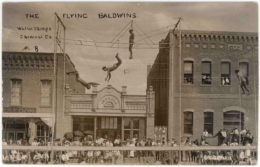 People doing acrobatics at a carnival in a Nebraska town in the early 1900s.