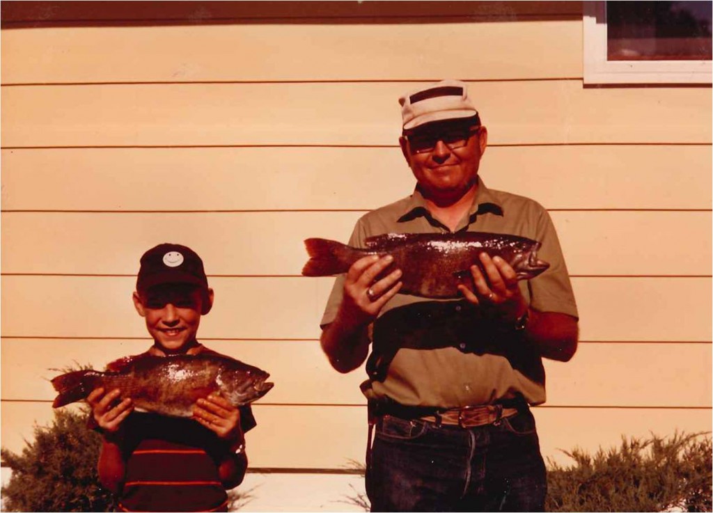 father and son holding fish