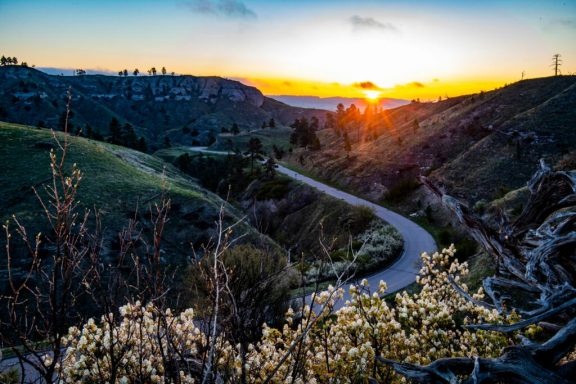 View overlooking a scenic canyon byway in a Nebraska state park as the sun sets in the background.