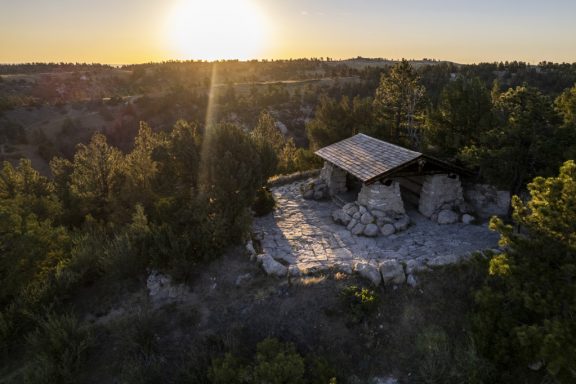 A stone picnic shelter on a hill.