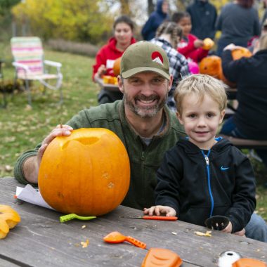 A man and his son carving a pumpkin at Ponca State Park's Hallowfest.