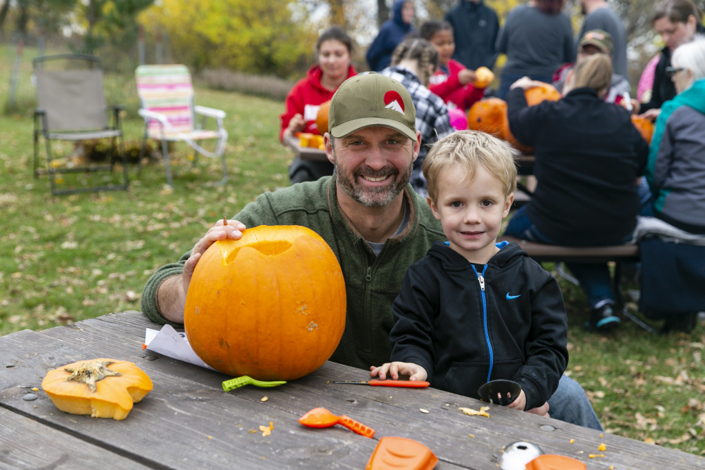 A man and his son carving a pumpkin at Ponca State Park's Hallowfest.