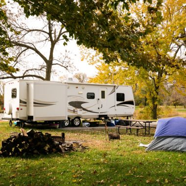 An RV and tent at a campsite in the fall.