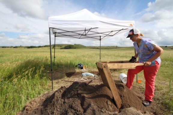 A University of Nebraska anthropology student Michelle Hayes attentively sifts through bucket-loads of dirt, hoping to spot artifacts.