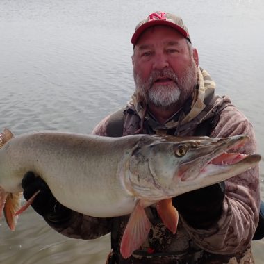 a man holding a muskie