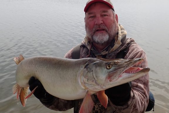 a man holding a muskie