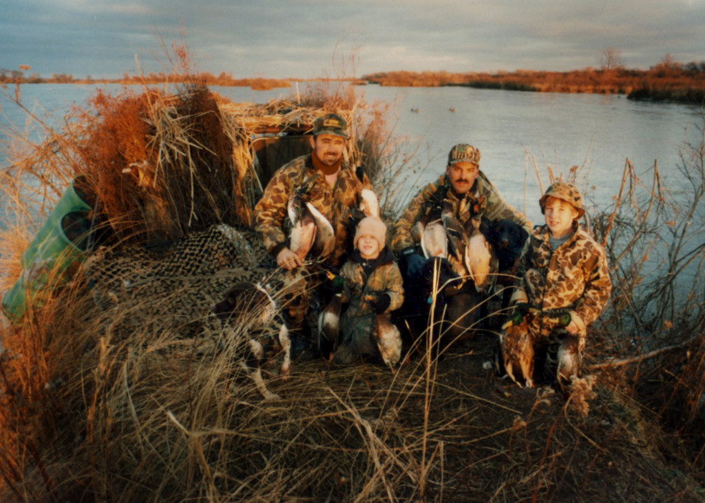 Photo of a family hunting waterfowl on a blind at a lake in 1998.