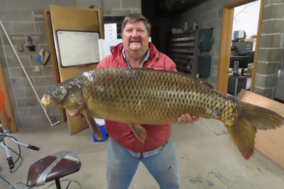 Man with 2023 state record common carp.