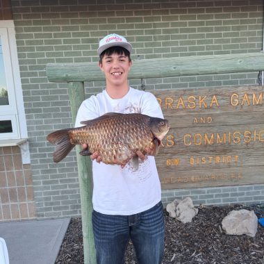 A young man holding a state record goldfish.