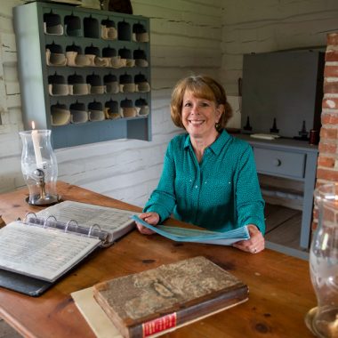 A woman sits at a table with research materials at Fort Atkinson State Historical Park.