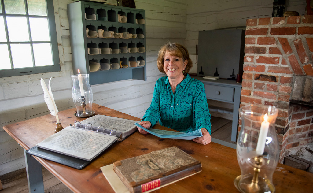 A woman sits at a table with research materials at Fort Atkinson State Historical Park.