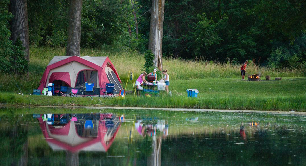 A family camps by a lake.