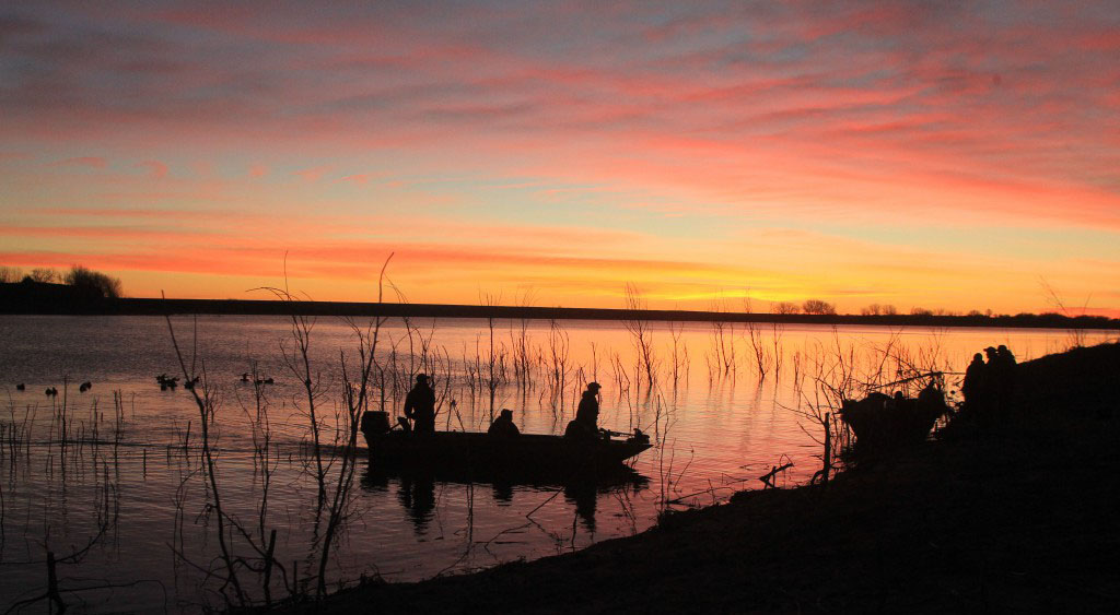 waterfowl hunters during sunrise.