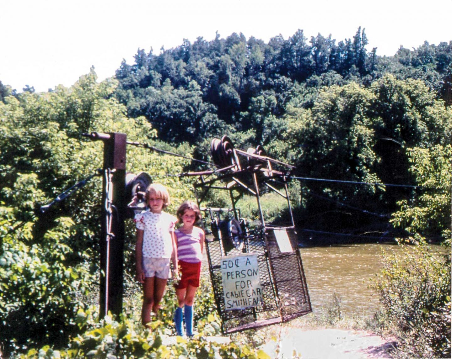 children pose with the old cable car that crossed the Niobrara River at Smith Falls State Park.