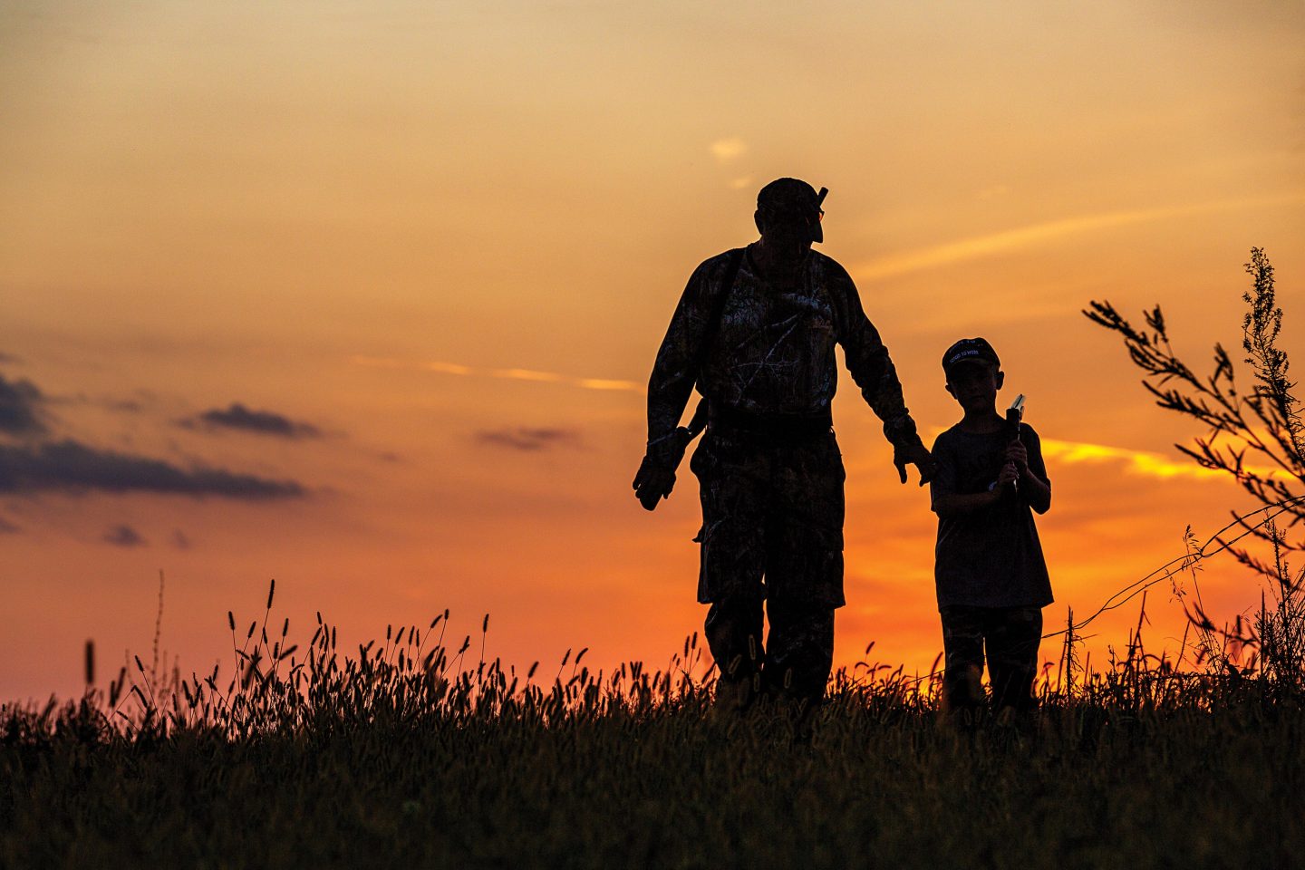 Man hunting with a young boy silhouette. 