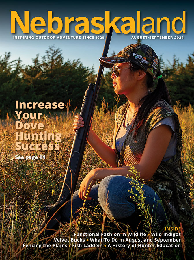 August-September 2024 cover of Nebraskaland Magazine featuring Nebraskaland Editor, Jenny Nguyen-Wheatley in a field with dove hunting gear.