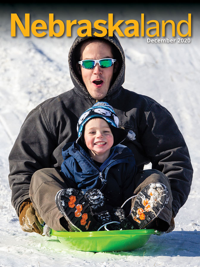 December cover of Nebraskaland featuring a dad and son sledding at Mahoney State Park.