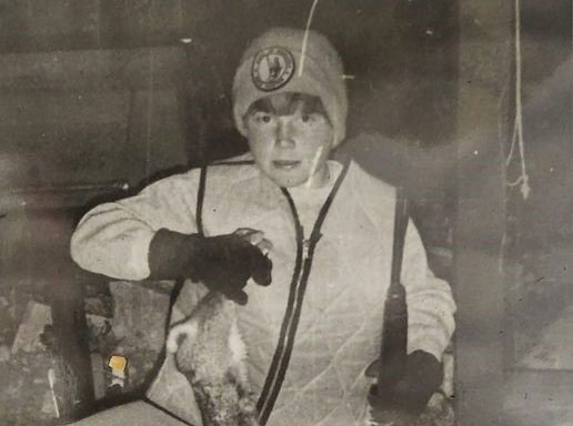 Vintage photo of a boy with a harvested rabbit