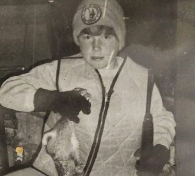 Vintage photo of a boy with a harvested rabbit