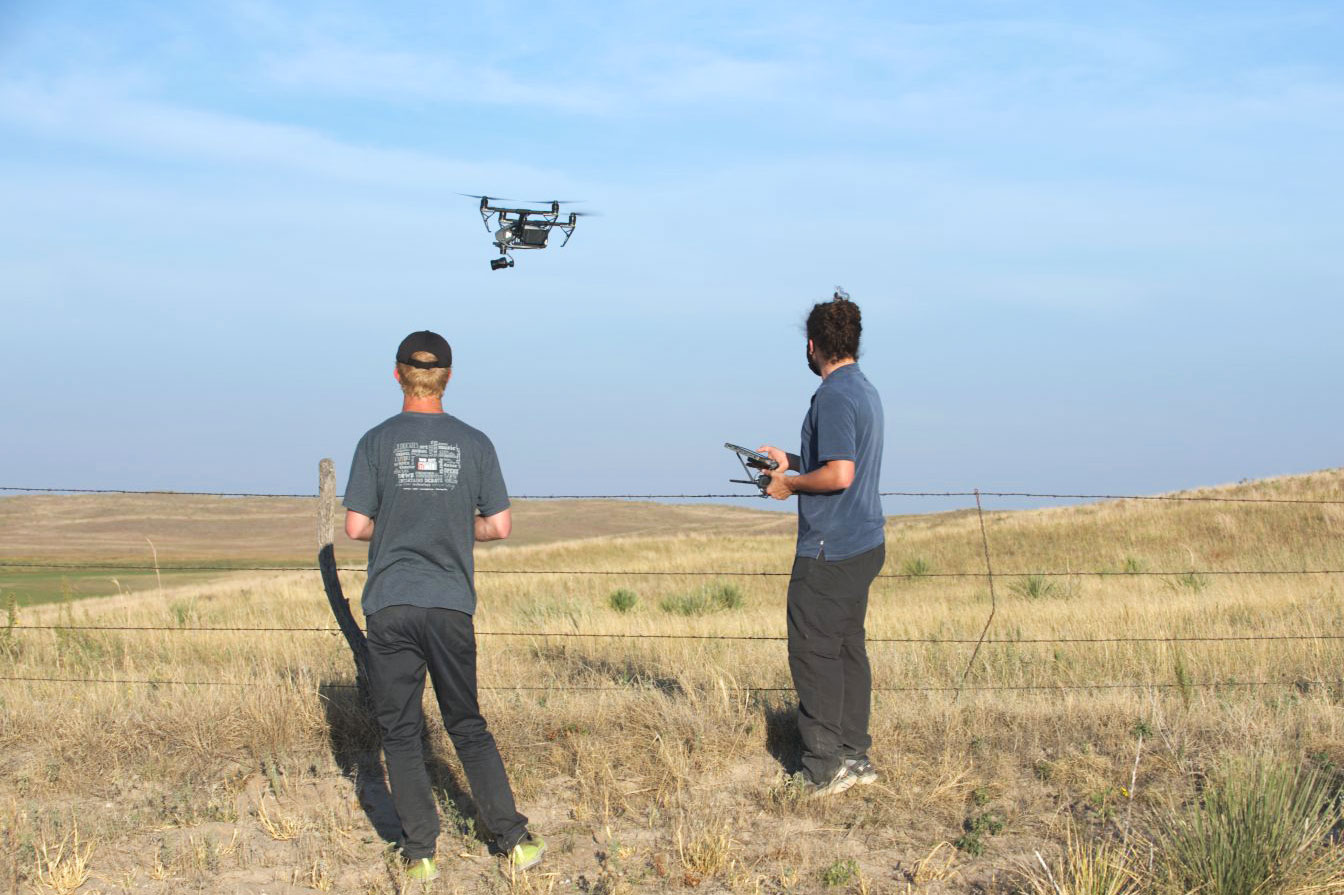 Game and Parks film producers operating a drone in a prairie.