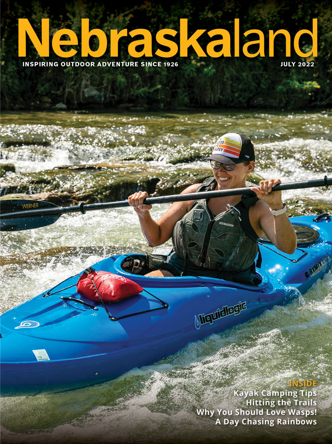 July 2022 Nebraskaland cover with a woman kayaking through rapids