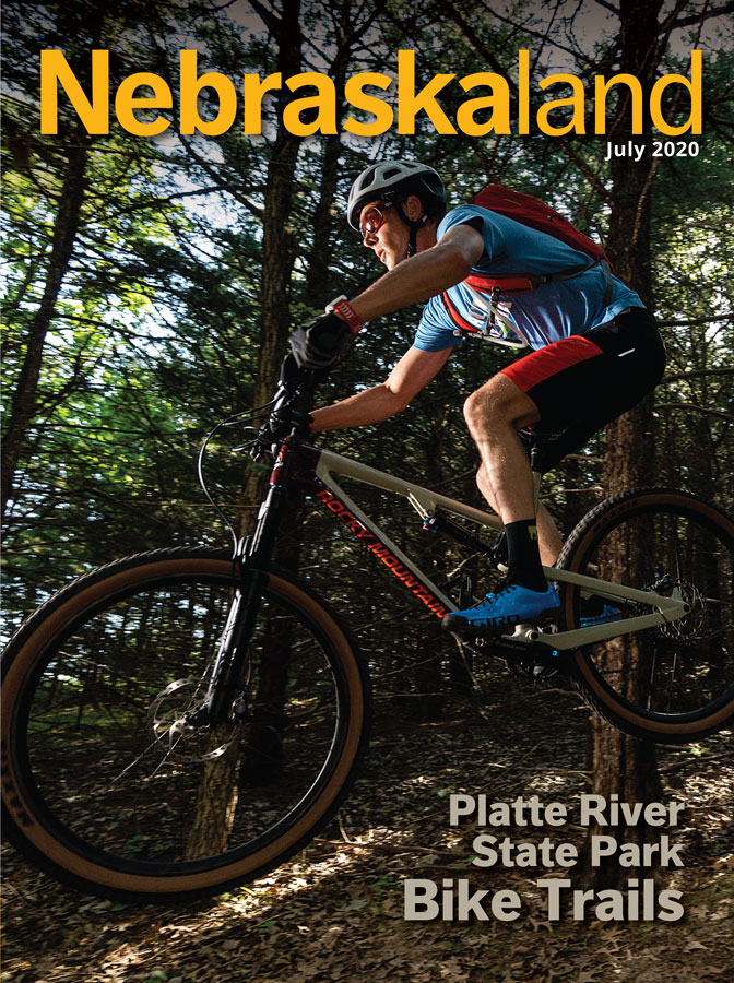 July 2020 cover of Nebraskaland featuring a mountain biker cycling at Platte River State Park.