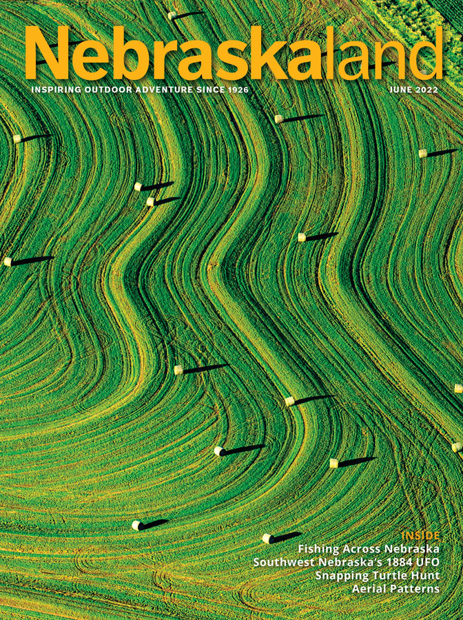 June 2022 Nebraskaland cover with an aerial view of a green hay field.