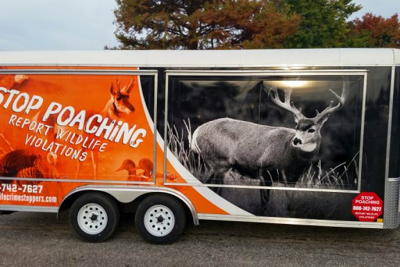 a picture of a trailer with 'Stop Poaching: Report Wildlife Violations" on it