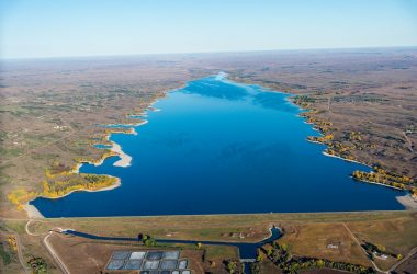 Aerial view of a blue reservoir in the fall.