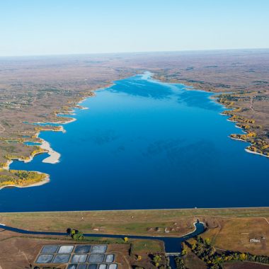 Aerial view of a blue reservoir in the fall.