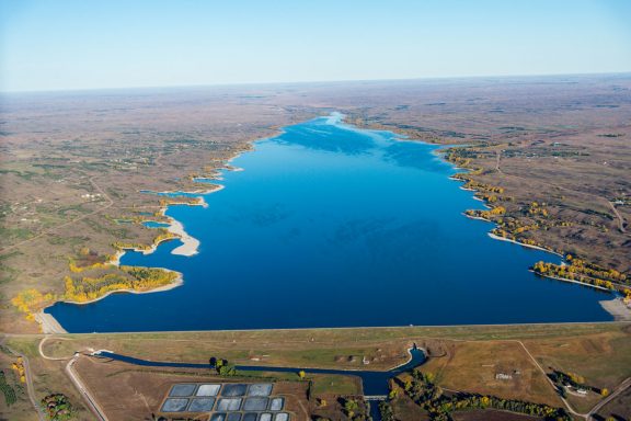 Aerial view of a blue reservoir in the fall.