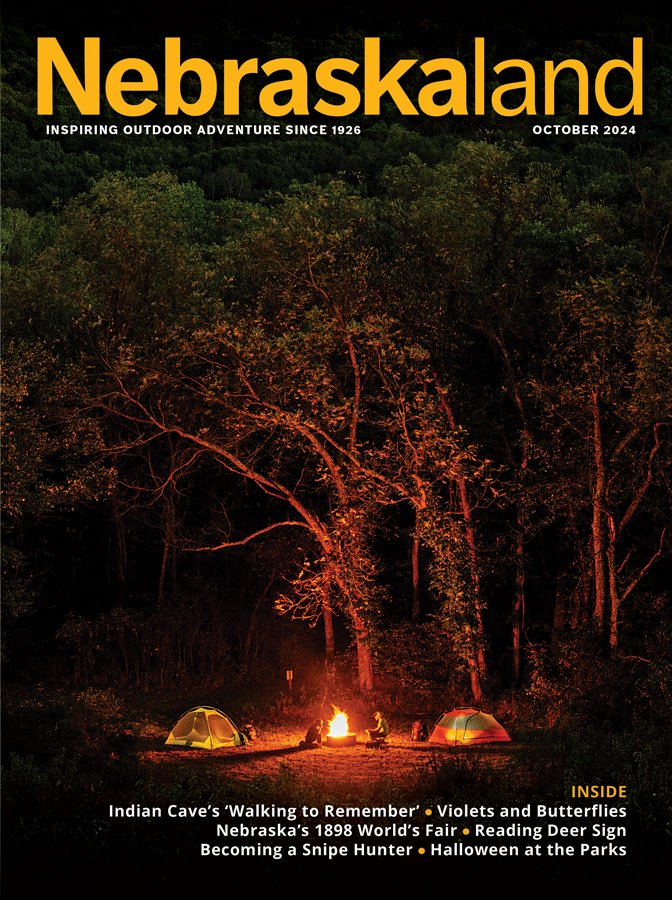 October 2024 Nebraskaland cover featuring a fall campfire scene at Indian Cave State Park.