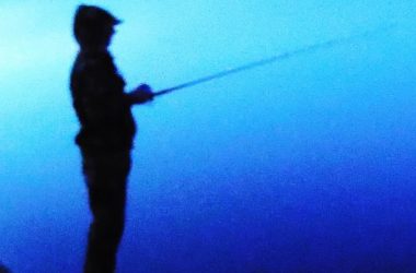 Silhouette of wading angler.