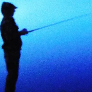 Silhouette of wading angler.