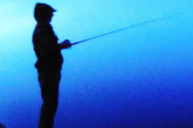 Silhouette of wading angler.