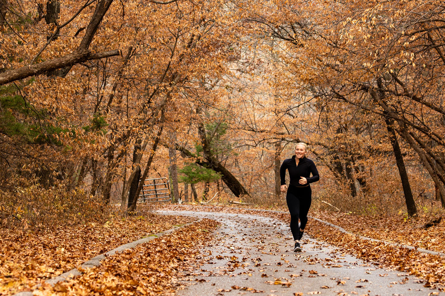 A woman running on a trail in the fall.